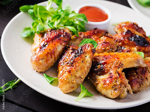 Grilled chicken wings. Baked chicken wings on wooden table.