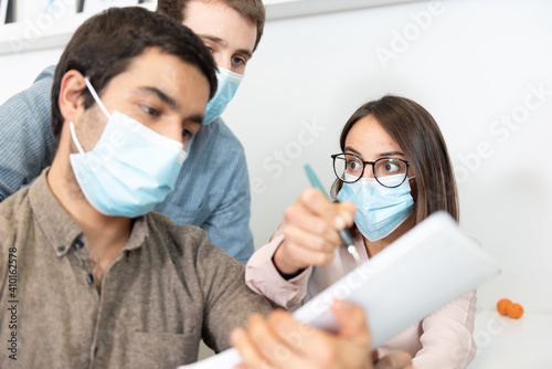 Coworkers wearing face masks contrasting opinions at the workplace. Working in the office during Coronavirus pandemic concept.