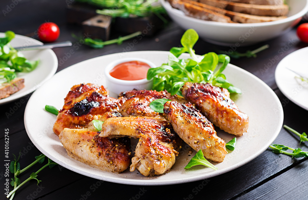 Grilled chicken wings. Baked chicken wings on wooden table.