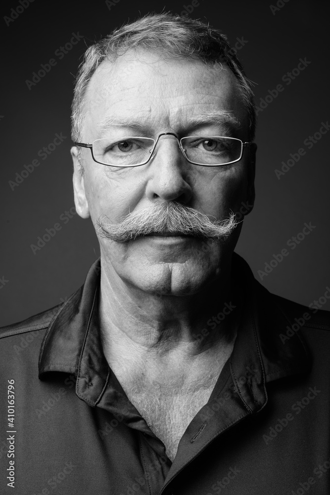 Portrait of handsome senior man with mustache wearing eyeglasses Portrait of handsome senior man with mustache wearing eyeglasses