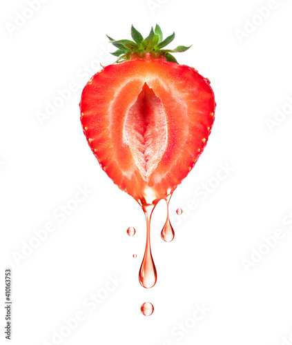 Foto A drop of juice drips from half a strawberry on a white background