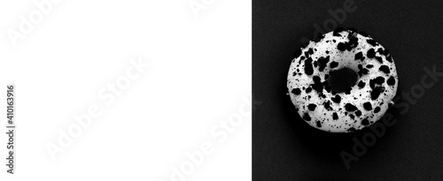 Creative mockup of a white donut with powder on a black and white background. Flat lay. Food concept. Macro concept