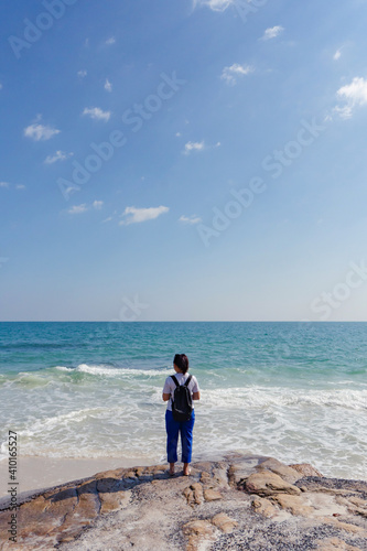 Young woman standing alone at the beach with copy space