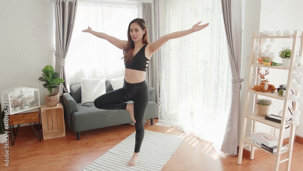 Young Asian women lovey with yoga exercise and stretching in the living room Young Asian women lovey with yoga exercise and stretching in the living room