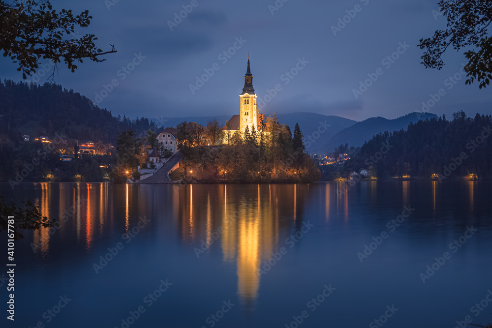 Evening twilight view of Pilgrimage Church of the Assumption of Maria lit up at Lake Bled, Slovenia in the Julian Alps.
