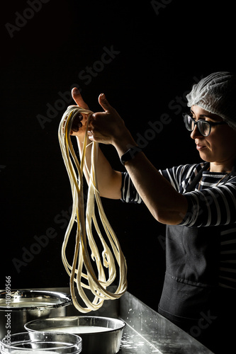 A woman working in a small family creamery is processing the final steps of making a cheese. Italian hard cheese silano or caciocavallo, mozzarella photo