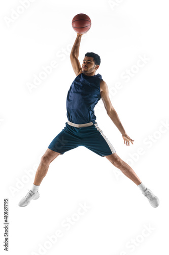 Slam dunk. Young arabian muscular basketball player in action, motion isolated on white background. Concept of sport, movement, energy and dynamic, healthy lifestyle. Training, practicing. © master1305