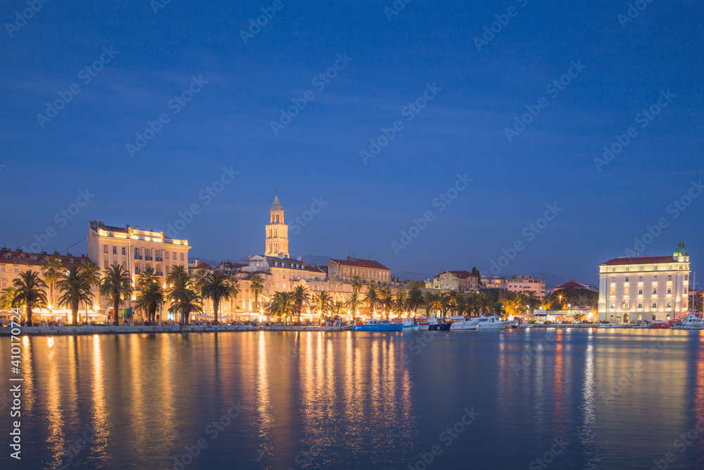 An evening view of the city lights of the Split waterfront and promenade on the Adriatic coast of Croatia.