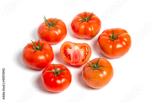 a group of tomatoes on a white background, with shadows. One tomato cut, studio photo, isolate, tomatoes washed