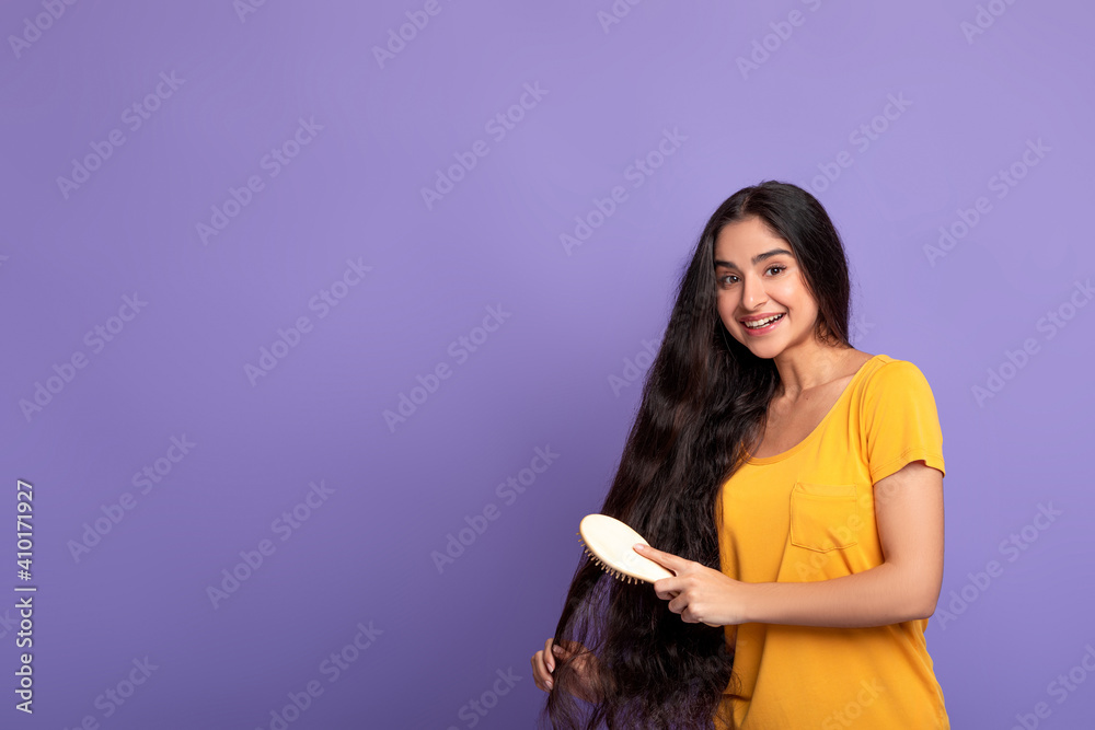 Smiling Young Indian Woman Brushing Long Hair With Wooden Comb Smiling Young Indian Woman Brushing Long Hair With Wooden Comb