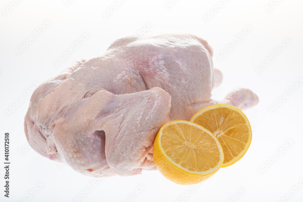 raw whole chicken with sliced lemon, isolated on white raw whole chicken with sliced lemon, isolated on white