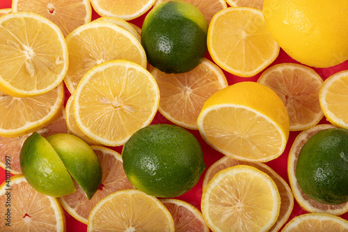 Fototapeta Naklejka Na Ścianę i Meble -  fresh limes and lemons sliced on red chopping board