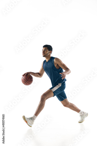 Competitive. Young arabian muscular basketball player in action, motion isolated on white background. Concept of sport, movement, energy and dynamic, healthy lifestyle. Training, practicing.
