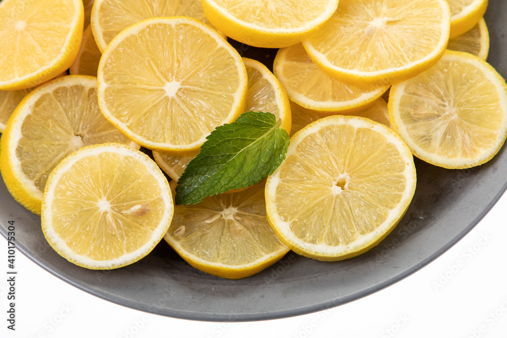 lemon slices on grey plate with white background 