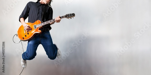 Male guitarist playing music and jump © BillionPhotos.com