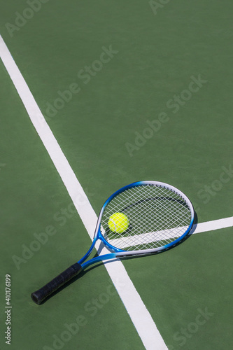 Tennis racket and tennis ball on court.