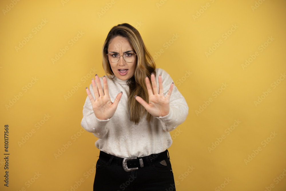 Pretty woman with long hair afraid and terrified with fear expression ...