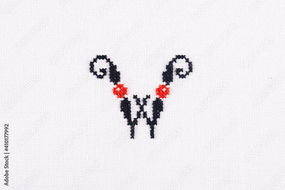 Letter W of Embroidered Cross - Stitch Latin Alphabet on White Linen Fabric Handmade Close-up