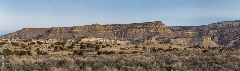 Large panoramic shot of rocky mountain range with open field on clear day in rural New Mexico