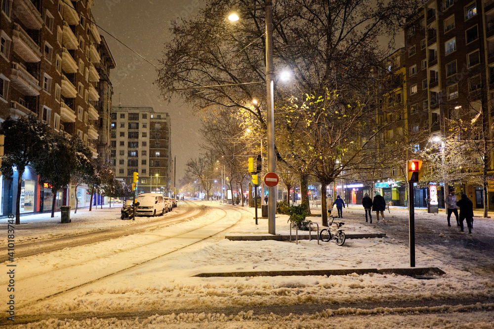 Street of a city at night on a snowy day.