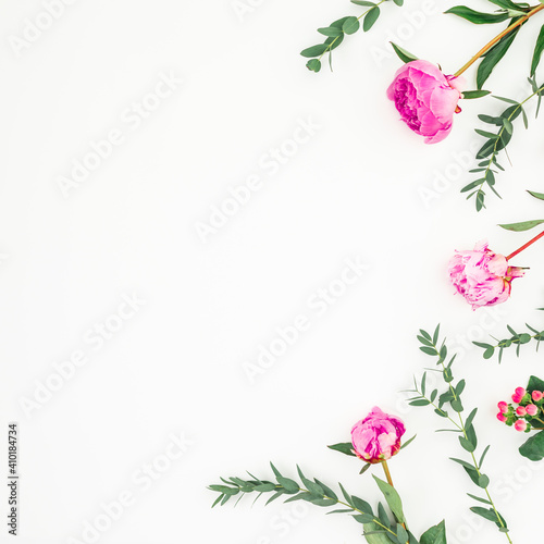 Floral frame made of pink peonies and eucalyptus branches on white. Flat lay, top view