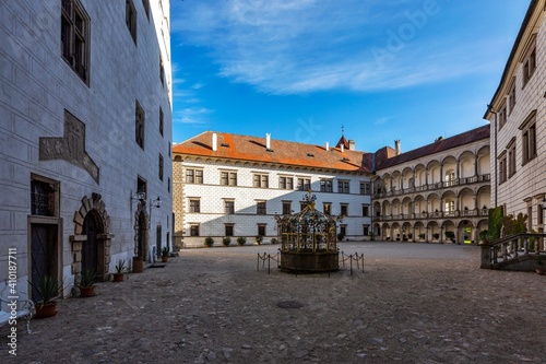 Jindrichuv Hradec, Czech Republic - September 26 2019: The courtyard of the Renaissance castle with white facade and arcades. Water well in the middle. Sunny day with blue sky.