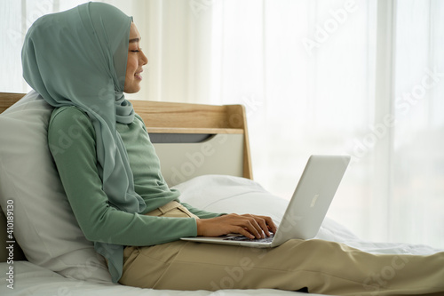 Asian business woman Muslim wearing HIJAB using laptop computer at home