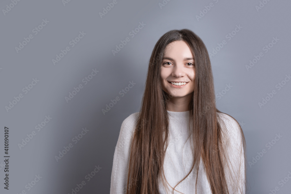 Fototapeta premium Pretty smiling joyfully female with dark hair, dressed casually, looking with satisfaction at camera, being happy. Studio shot of good-looking beautiful woman isolated against blank studio wall.