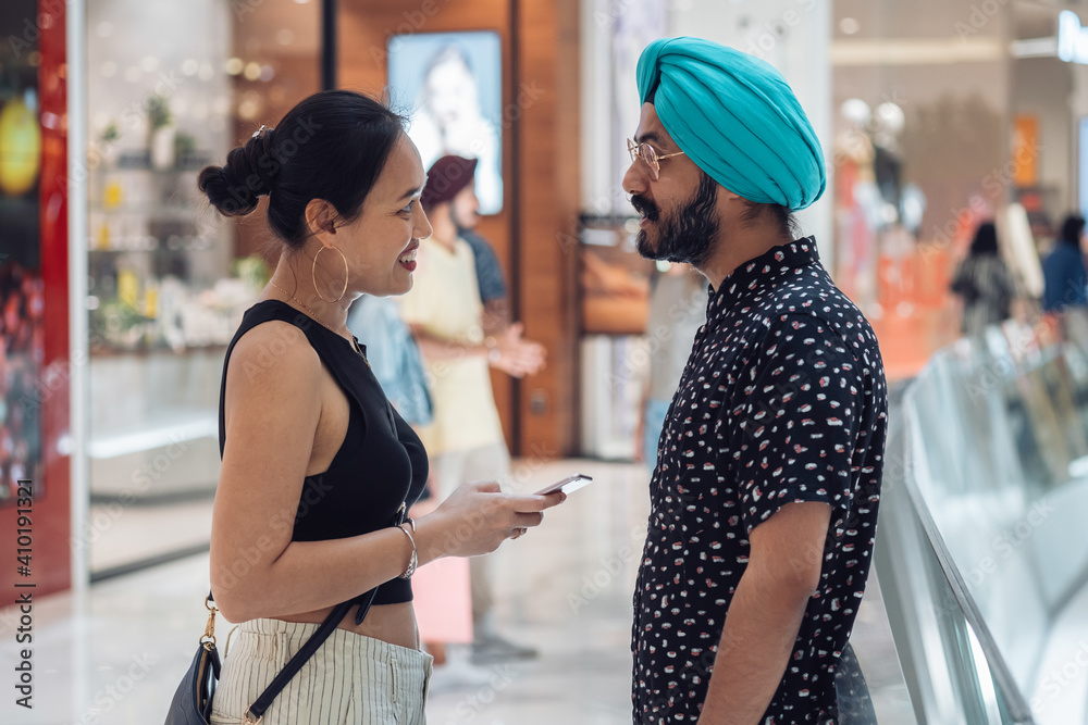 Beautiful loving couple talking in shopping mall