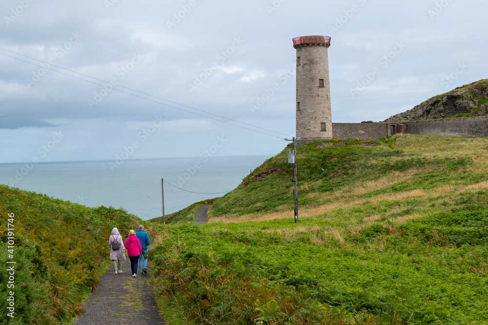 Group of people walks along Wicklow Head Lighthouse