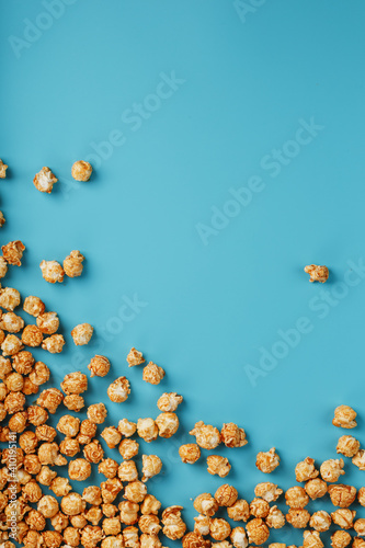 Caramel popcorn by a ripple on a blue background, in the form of a frame.