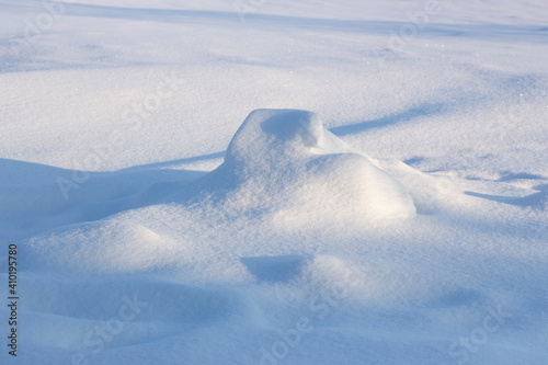Snowdrift and shadow. Snowy background, winter snow texture on a sunny evening.