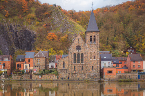 Fotografie The Church of Saint Paul along the Meuse River in the picturesque town of Dinant, Belgium on an autumn day
