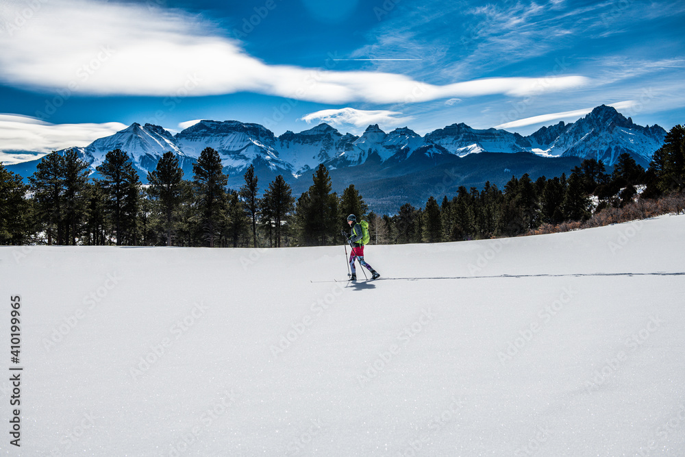 woman skiing past mountain range