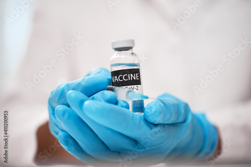 Coronavirus Vaccine concept in hand of doctor with blue gloves