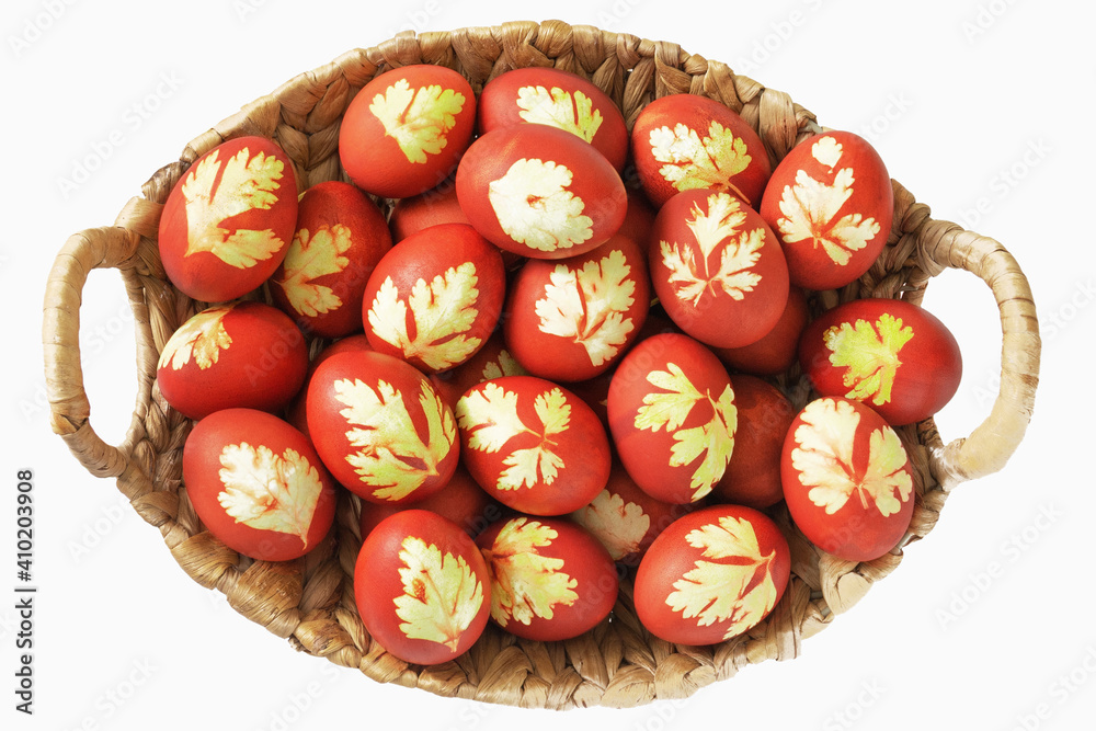 Orthodox Easter. Colored eggs in basket on white background. Top view. Closeup