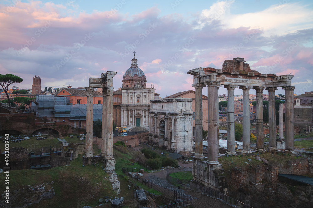 Evening sunset view of historic ruins of the Roman Forum and Palatino Hill in Rome, Italy, a popular tourist attraction.