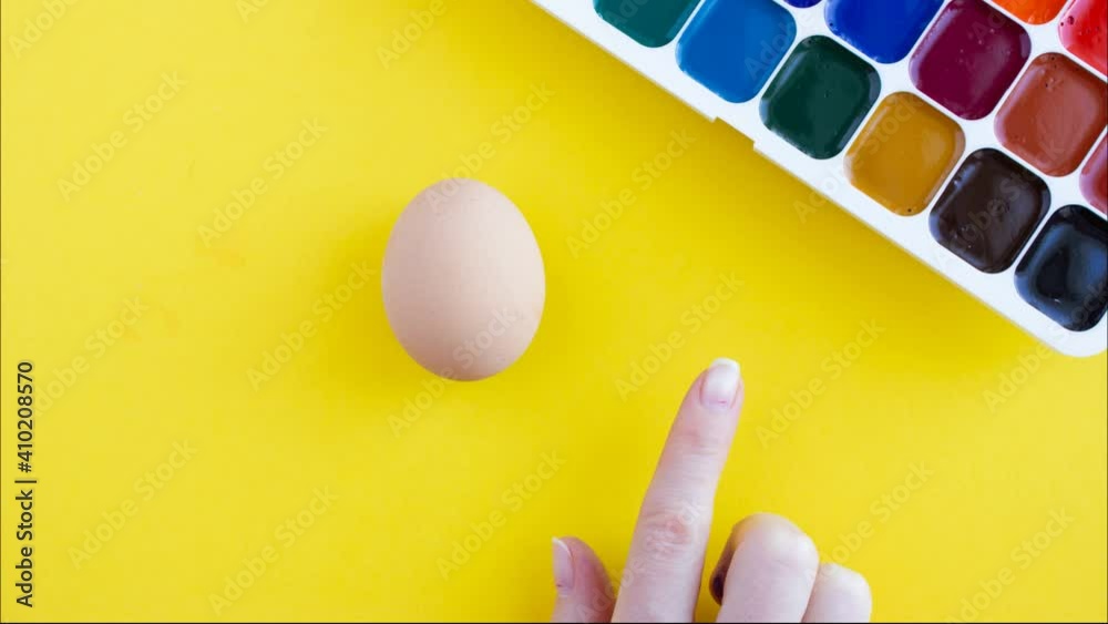 Creative finger painting easter eggs with red and blue paint, stop motion animation on yellow background