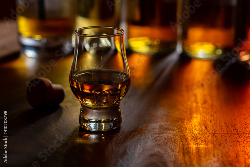 Fototapeta Naklejka Na Ścianę i Meble -  Dram of single malt scotch whisky and bottles on background