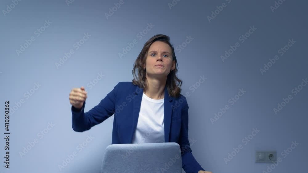 beautiful woman in business suit singing and dancing on gray background. beautiful woman in business suit singing and dancing on gray background.