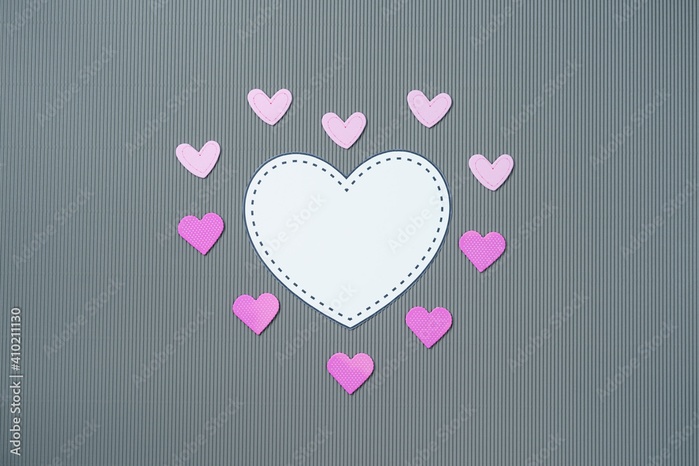 Paper elements in shape of hearts on gray background. Symbols of love for Happy Women's, Mother's, Valentine's Day, birthday greeting card design.