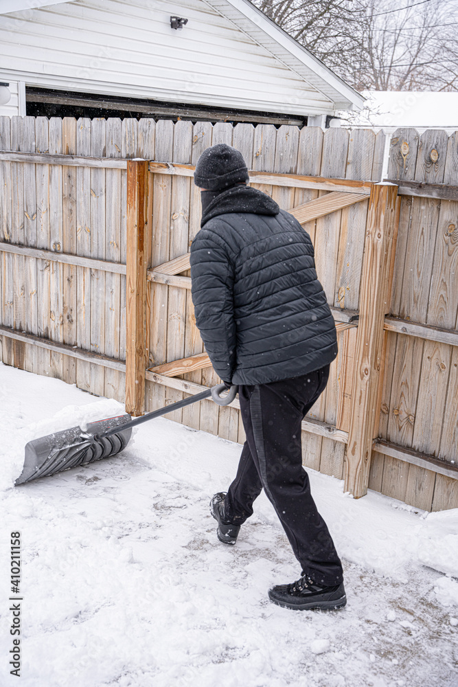 man is shoveling snow from your sidewalk and driveway after a recent snow storm man is shoveling snow from your sidewalk and driveway after a recent snow storm