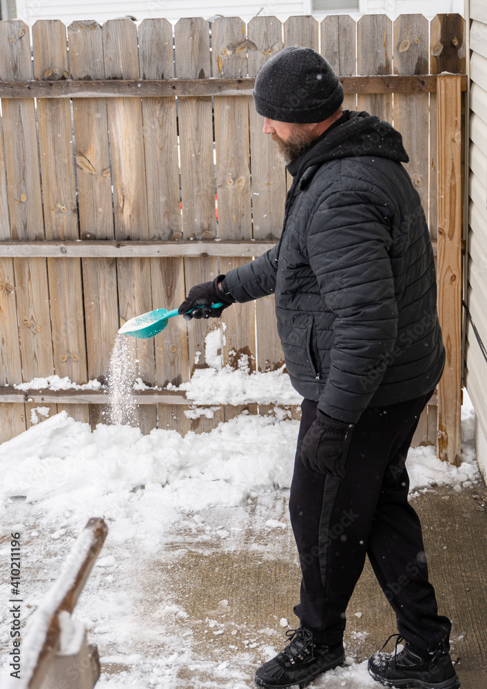 man is spreading salt to melt the ice on your path man is spreading salt to melt the ice on your path