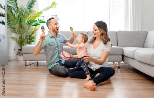 happy mother and father with baby daugter playing at home photo