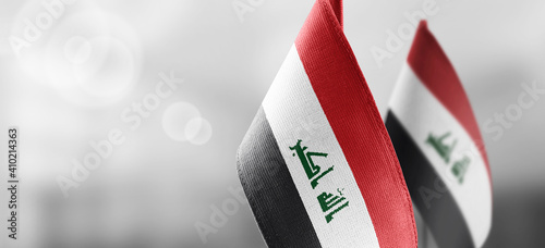 Small national flags of the Iraq on a light blurry background photo
