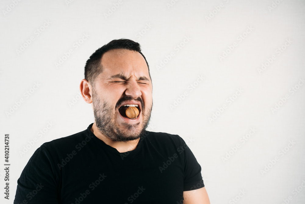 a man tries to crack a nut with his teeth. the concept of a complex problem or strong teeth a man tries to crack a nut with his teeth. the concept of a complex problem or strong teeth