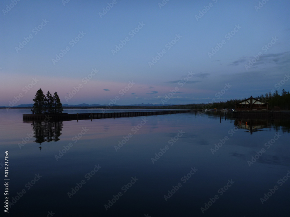 Pink and purple sky colors reflected in a lake at yellowstone national park at twilight