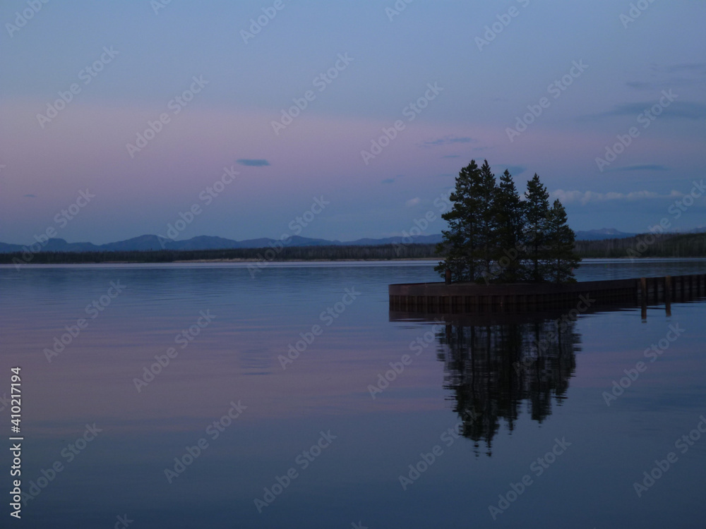 Pink and purple sky colors reflected in a lake at yellowstone national park at twilight