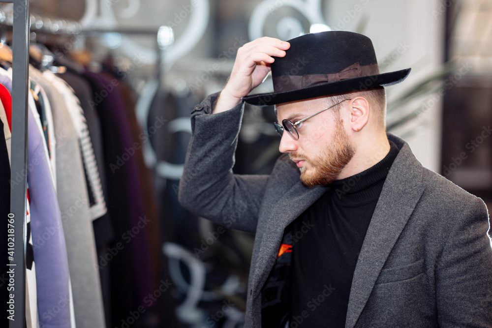 Man in a clothing store trying on a hat Man in a clothing store trying on a hat