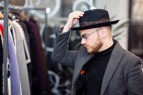 Man in a clothing store trying on a hat